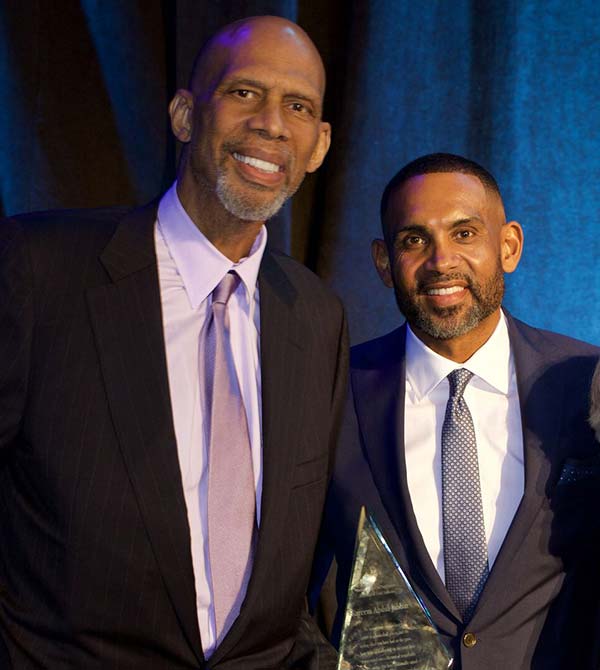 Kareem Abdul-Jabbar and Grant Hill pose together with an award at the gala