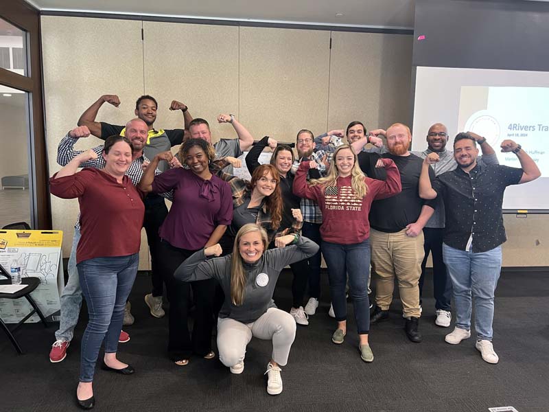 Workshop participants flexing their arms together during a training session